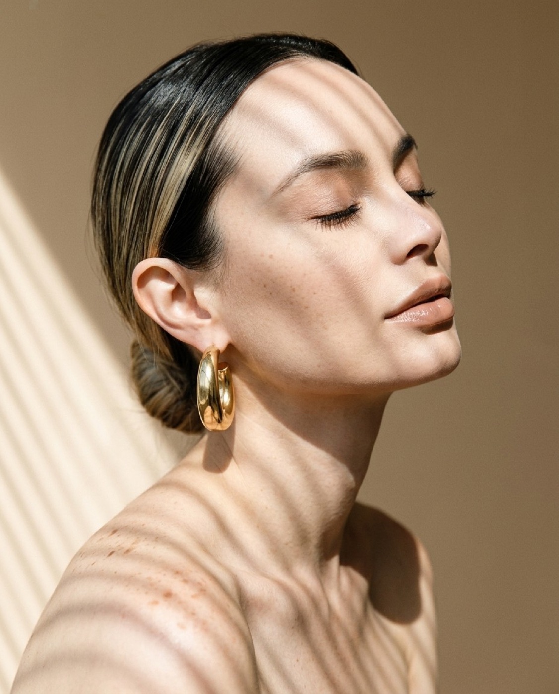 Retrato editorial de Lili Duque con aretes dorados
